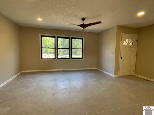 interior space with ceiling fan and a textured ceiling