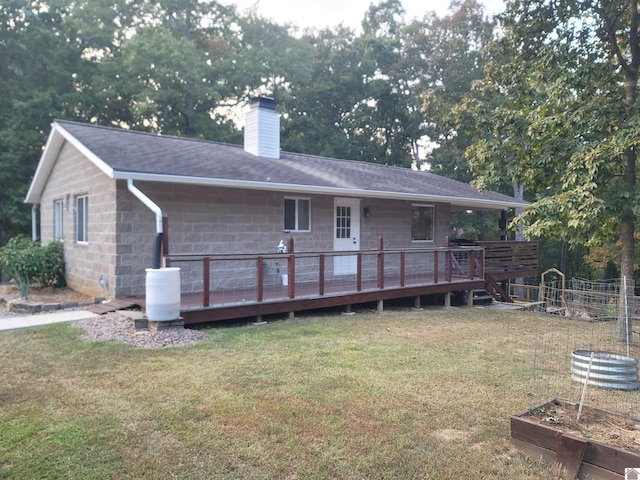 rear view of house with a lawn and a wooden deck