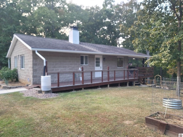 back of property with a yard and a deck