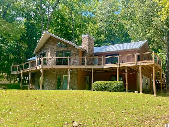 rear view of property with a wooden deck and a lawn