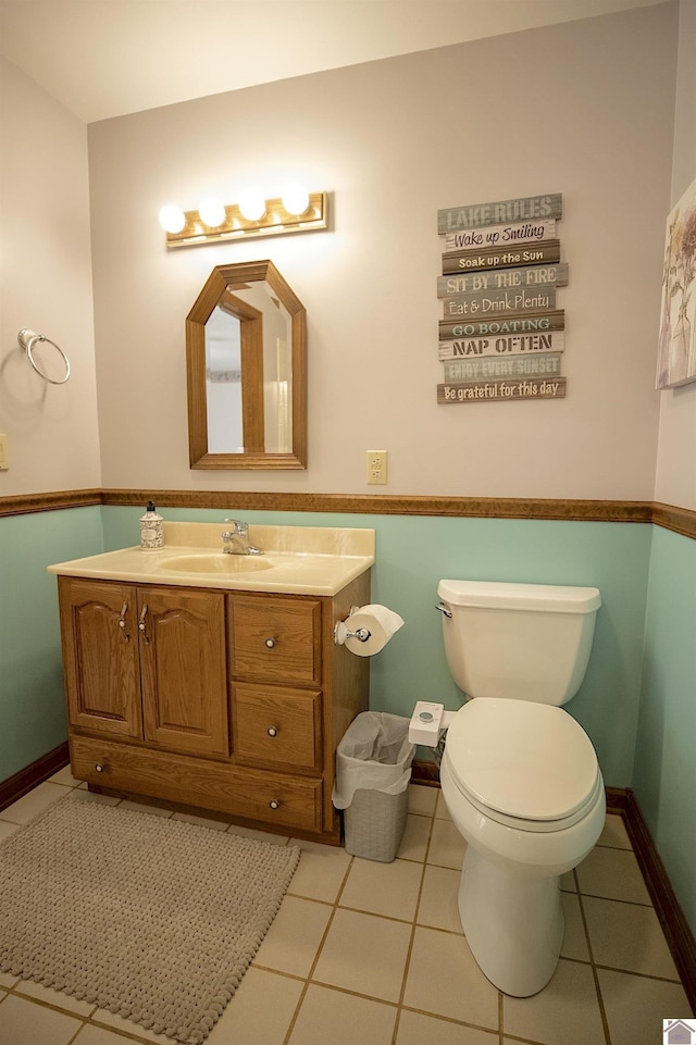 bathroom with toilet, vanity, tile patterned floors, and baseboards