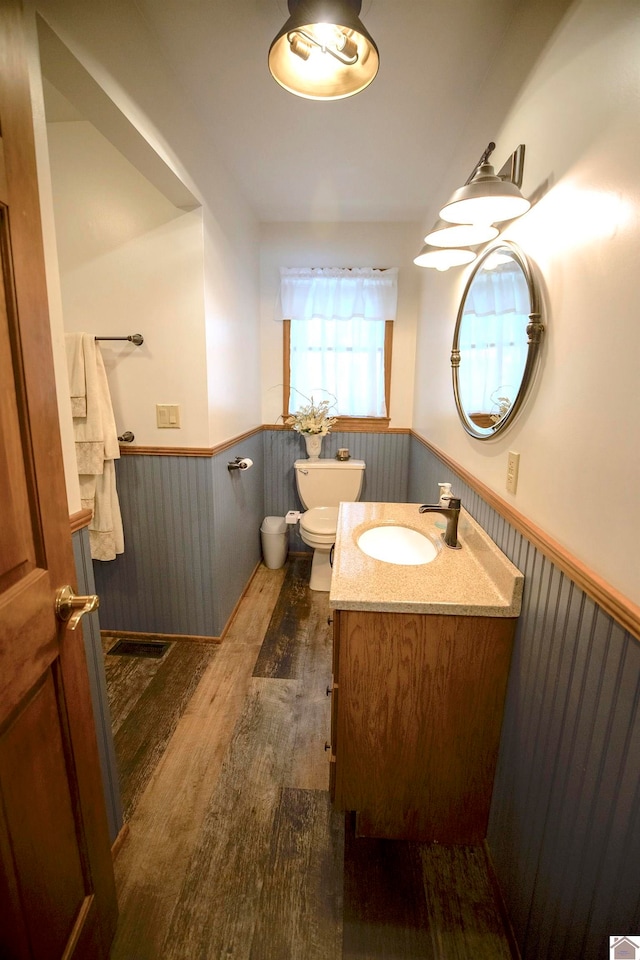 bathroom with vanity, toilet, and hardwood / wood-style flooring