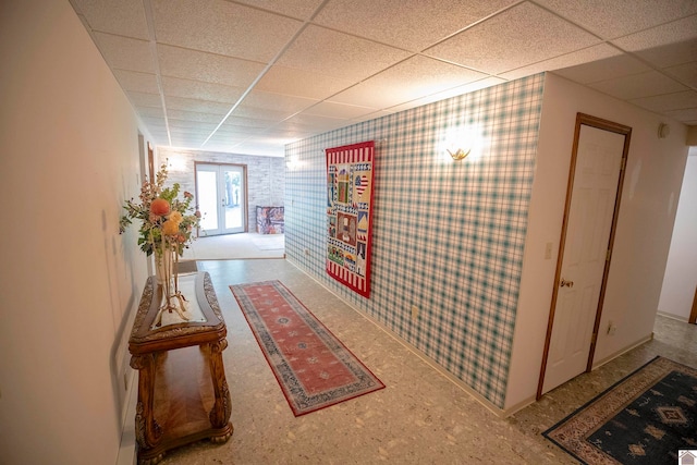 hallway with a paneled ceiling