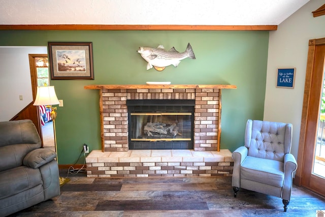 living area featuring a fireplace, vaulted ceiling, and wood-type flooring