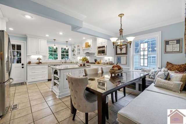 tiled dining room featuring ornamental molding, a notable chandelier, and sink