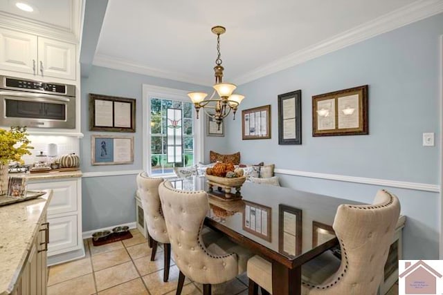 dining room featuring a notable chandelier, light tile patterned floors, and ornamental molding