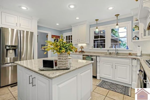 kitchen featuring pendant lighting, sink, a kitchen island, white cabinetry, and appliances with stainless steel finishes