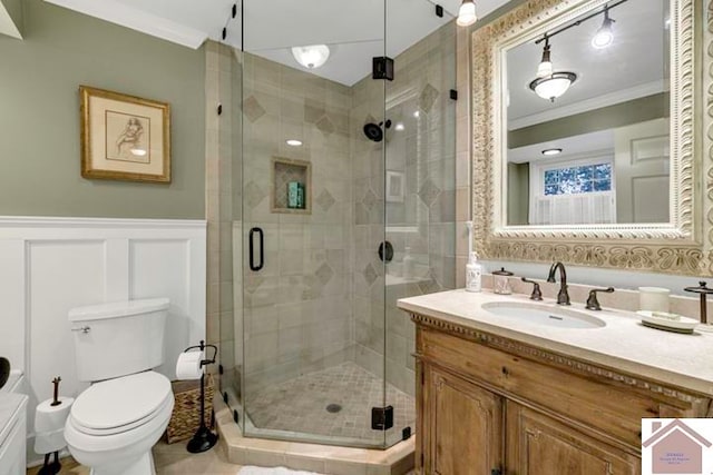 bathroom featuring crown molding, vanity, toilet, and an enclosed shower