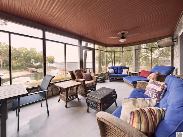 sunroom / solarium featuring a water view and ceiling fan