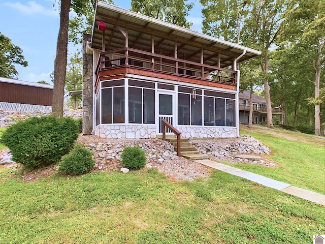 back of property featuring a lawn and a sunroom