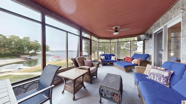 sunroom / solarium with a water view and ceiling fan