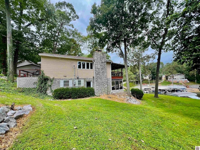 rear view of house featuring a lawn