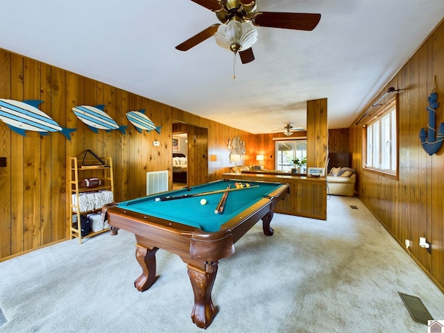 rec room with pool table, wooden walls, ceiling fan, and light colored carpet