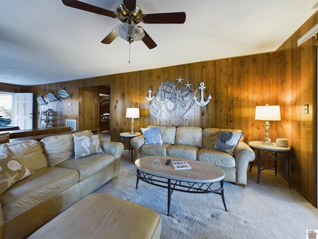 living room featuring carpet flooring, wood walls, and ceiling fan