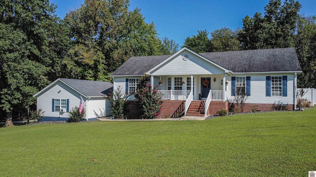 ranch-style home featuring covered porch and a front yard