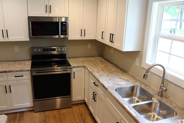 kitchen with stainless steel appliances, dark hardwood / wood-style flooring, sink, and white cabinets