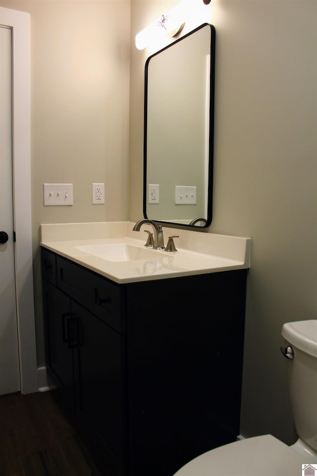 bathroom featuring vanity, hardwood / wood-style flooring, and toilet