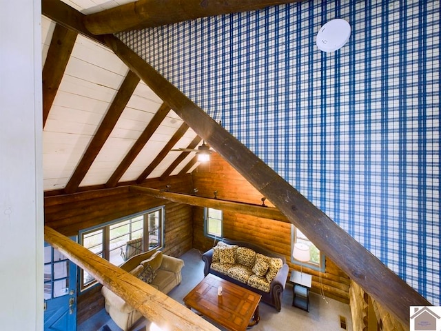 living room featuring ceiling fan, lofted ceiling with beams, and wood walls