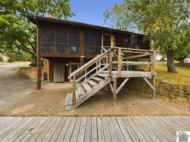 back of house with a sunroom and a wooden deck