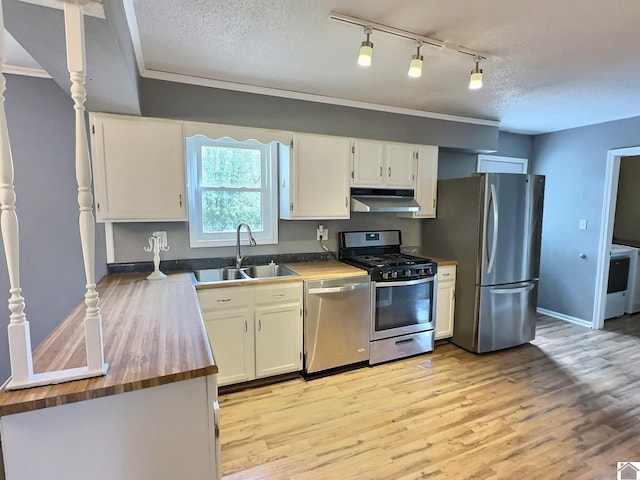 kitchen with white cabinets, sink, a textured ceiling, appliances with stainless steel finishes, and light wood-type flooring