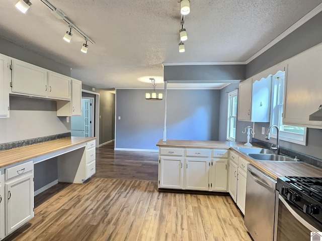 kitchen with white cabinets, dishwasher, pendant lighting, light hardwood / wood-style flooring, and sink