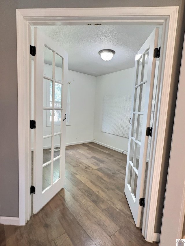 interior space featuring french doors, a textured ceiling, and hardwood / wood-style floors