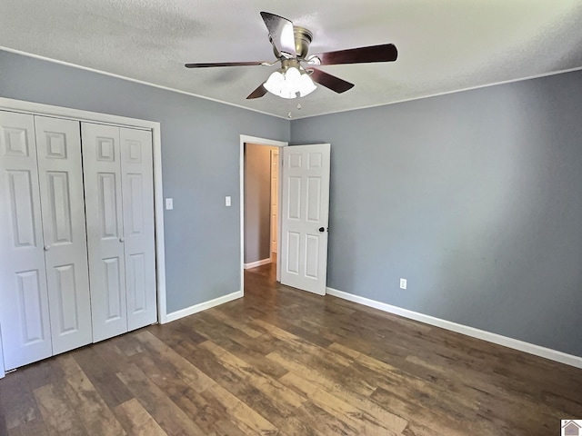 unfurnished bedroom featuring a textured ceiling, dark hardwood / wood-style flooring, ceiling fan, and a closet