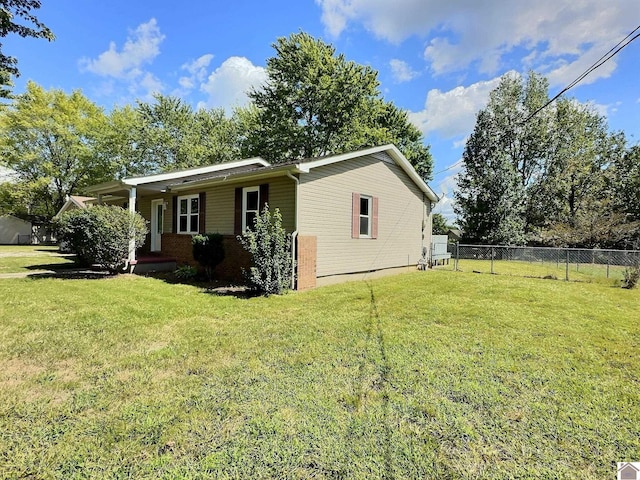 view of side of property with fence, a porch, and a yard