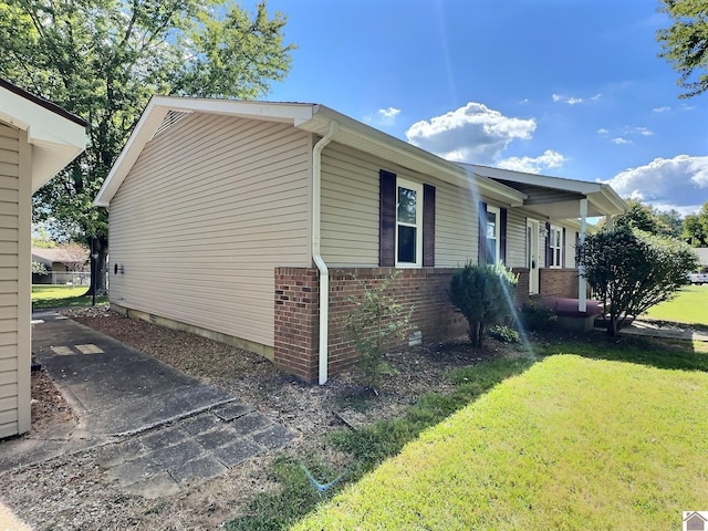 view of property exterior with a lawn and brick siding