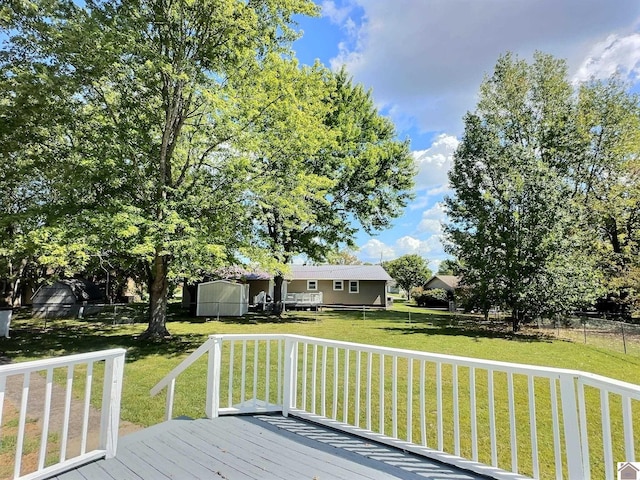 wooden deck featuring a lawn and a storage shed