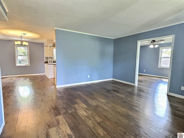 unfurnished living room with ornamental molding, a textured ceiling, plenty of natural light, and dark wood-type flooring