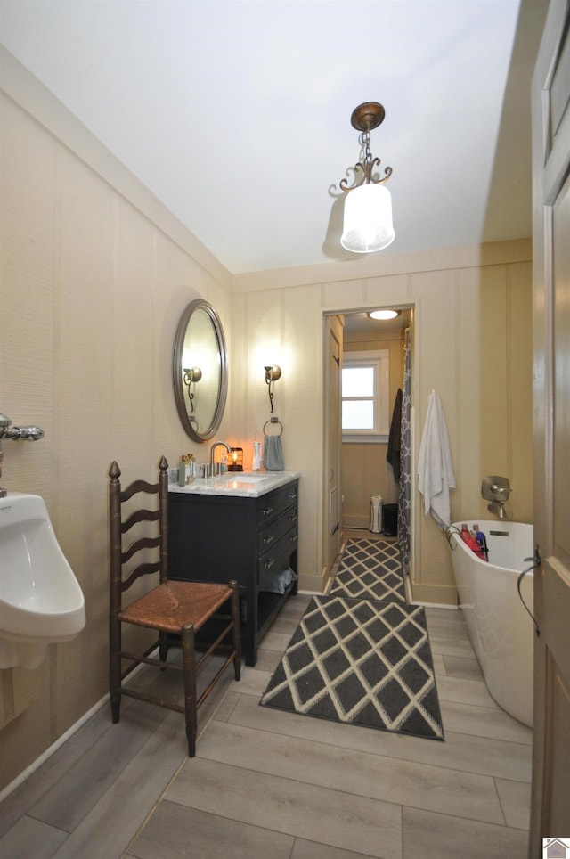 bathroom with a tub to relax in, vanity, and hardwood / wood-style floors