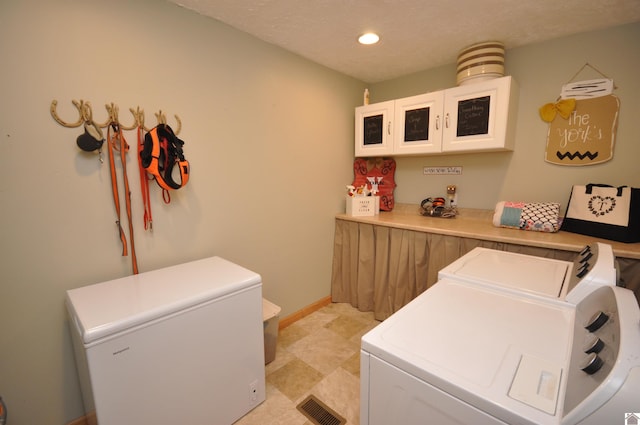 washroom with a textured ceiling and independent washer and dryer