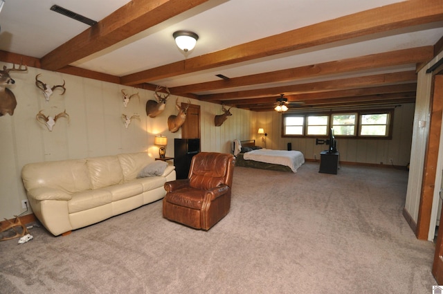 carpeted living room with beam ceiling