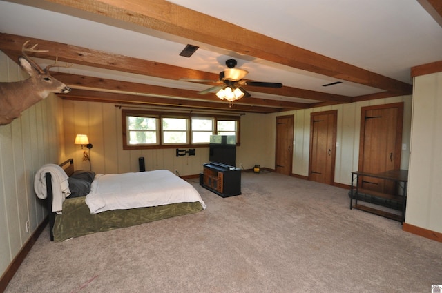 carpeted bedroom with ceiling fan and beamed ceiling