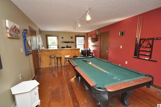 rec room with indoor bar, pool table, dark wood-type flooring, and rail lighting