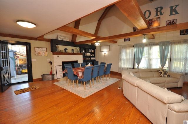 living room featuring lofted ceiling with beams, hardwood / wood-style floors, and a fireplace