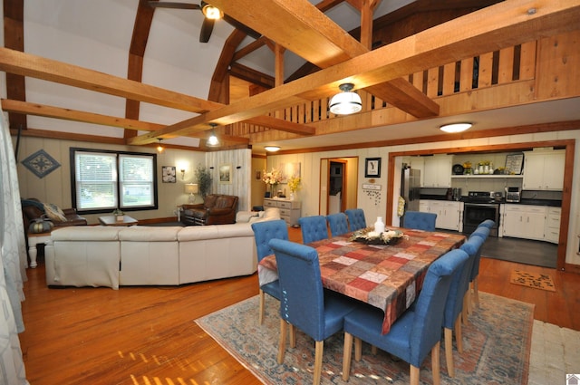 dining area featuring wood-type flooring and lofted ceiling with beams