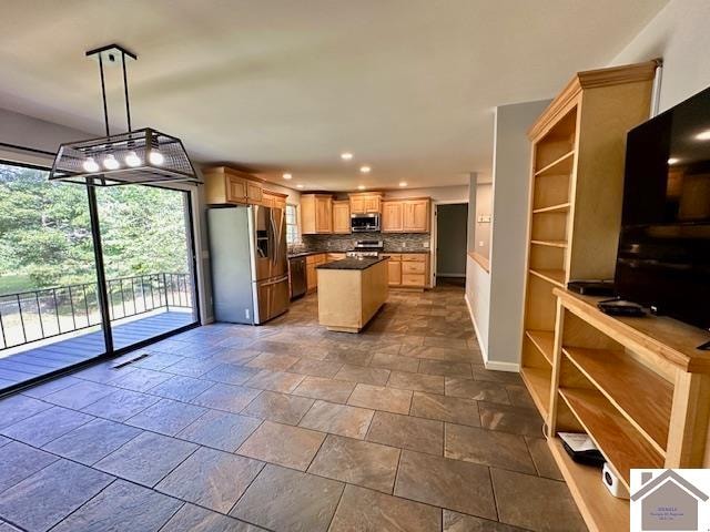 kitchen with pendant lighting, a center island, appliances with stainless steel finishes, and tasteful backsplash