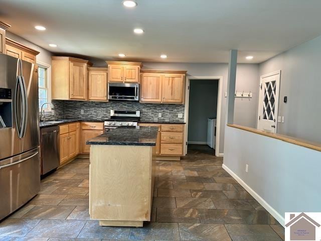 kitchen with light brown cabinets, sink, tasteful backsplash, stainless steel appliances, and a center island