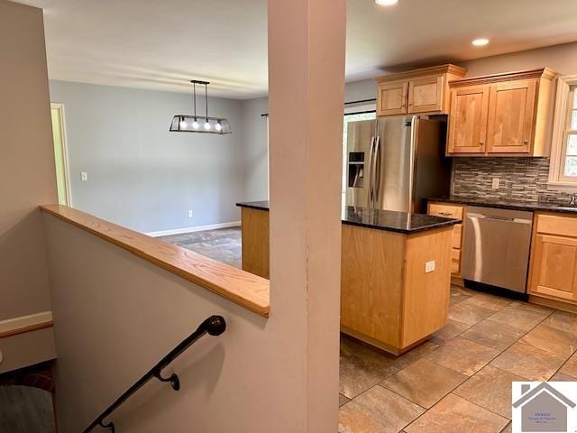 kitchen featuring pendant lighting, stainless steel appliances, decorative backsplash, and light brown cabinets