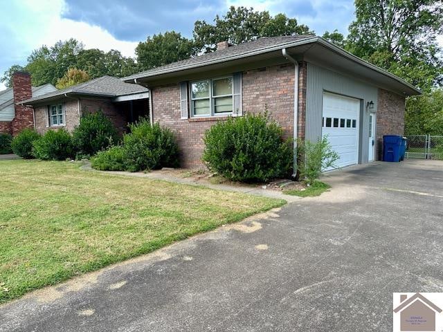 single story home with a garage and a front lawn