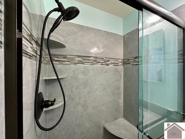 bathroom with a shower with shower door