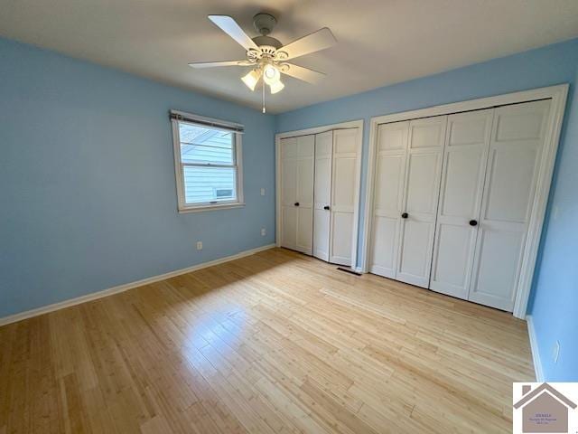 unfurnished bedroom with light hardwood / wood-style flooring, two closets, and ceiling fan