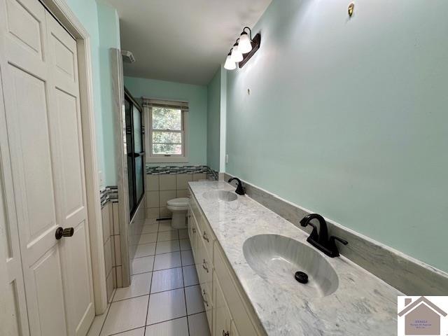 bathroom featuring vanity, tile patterned floors, walk in shower, tile walls, and toilet