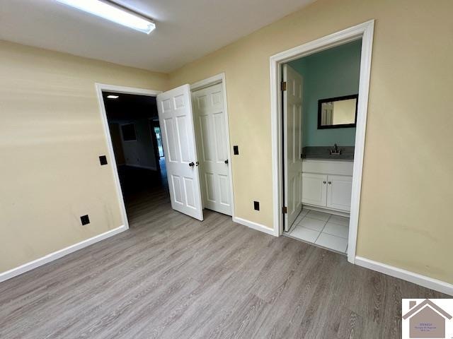 interior space featuring light wood-type flooring and ensuite bath