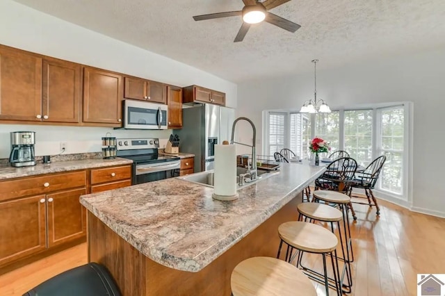 354 Sassafrass Rd, Cadiz, KY 42211 - kitchen featuring stainless steel appliances, a textured ceiling, brown cabinetry, ceiling fan, and a sink