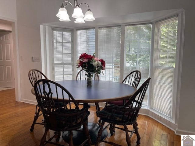 dining space featuring light hardwood / wood-style flooring and a chandelier