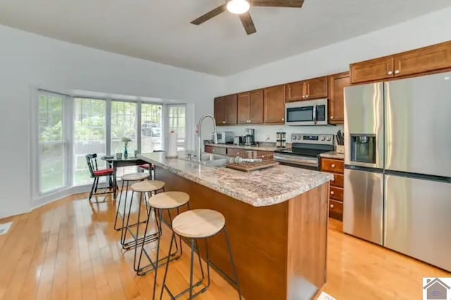354 Sassafrass Rd, Cadiz, KY 42211 - kitchen featuring stainless steel appliances, light wood-type flooring, ceiling fan, and a kitchen bar