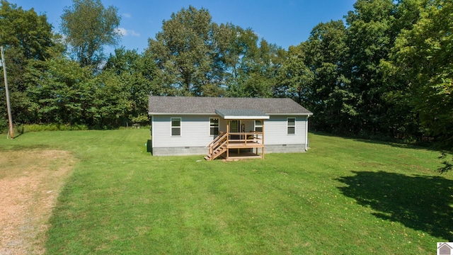 rear view of property featuring a yard and a deck